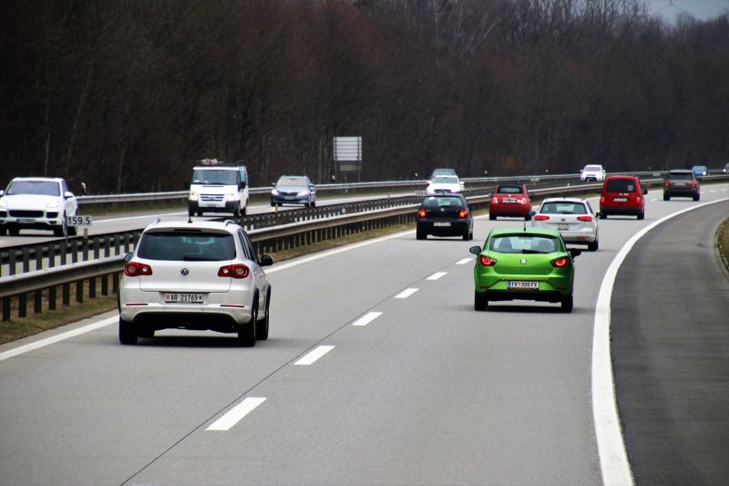 Autos fahren auf einer vierspurigen Autobahn, aus einem fahrenden Auto aufgenommen.