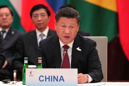 Xi Jinpng spricht im Sitzen, vor sich ein Schild mit der Aufschrift "China"
