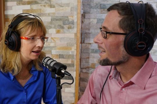 Cornelia und Volker Quaschning nehmen mit Kopfhörern und Mikrofon eine Podcast-Folge auf.