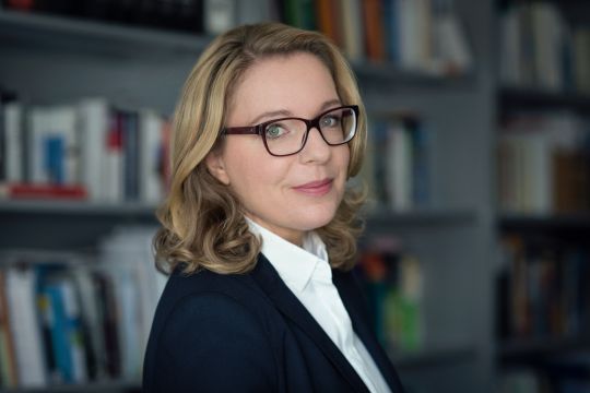 Claudia Kemfert vor verschwommener Bücherwand